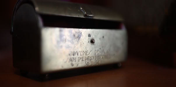 Caja metálica antigua sobre una superficie de madera.